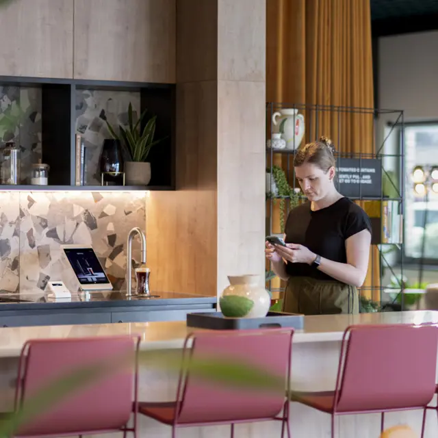 Wide shot in Uncle Southall showing a TopBrewer coffee machine and people in the background