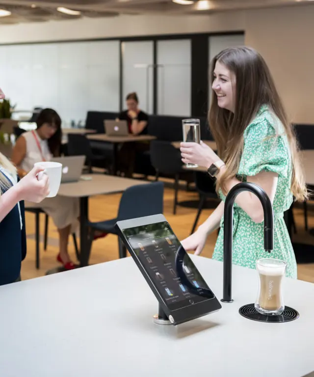 Image showing matte black TopBrewer with deluxe iPad holder and two people chatting next to it