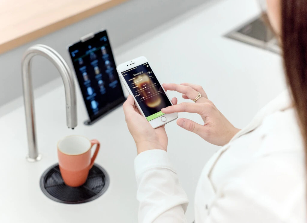 Woman brewing coffee with TopBrewer mobile app